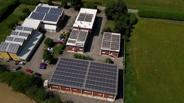 Industrial Rooftop Solar Panels: An aerial view showcases an industrial complex with numerous buildings, each adorned with an abundance of solar panels on their rooftops.