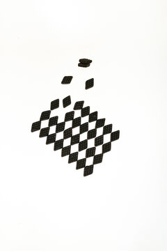 Black salty liquorice candies form a geometric pattern on white