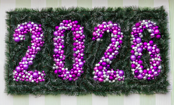 2026 year sign with festive purple Christmas bulbs background on wall outside
