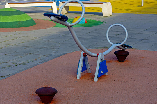 Modern empty metal seesaw play equipment inside children playground