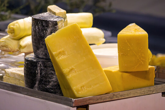 Traditional cheese selection pile on market stall outside