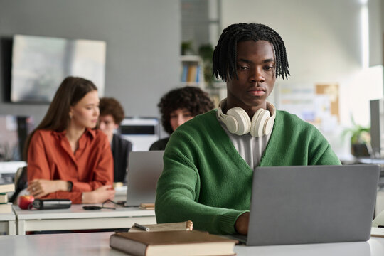 Male student types on a laptop during class indoors