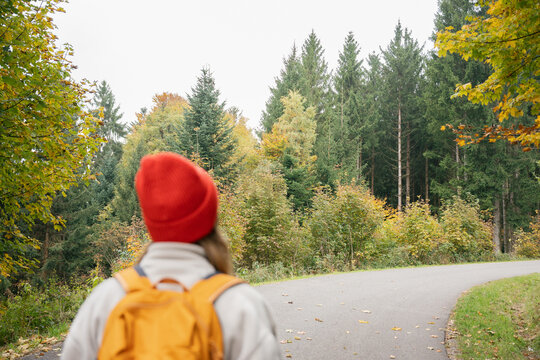 Woman explores a forest trail during an autumn adventure