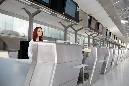 Germany, Cologne, Young woman at ticket counter