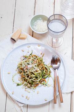 Spiralized carrot and zucchini pasta with pesto, parmesan cheese, and pine nuts