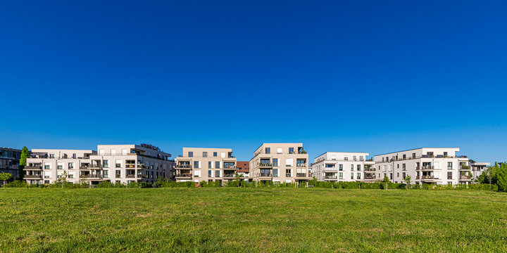 Modern apartment buildings border a green meadow in Fellbach