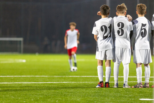 Junior Soccer Wall Defensive Line Standing Together During Opponent Free Kick - Youth Football Players in White Jerseys Watching Field Action