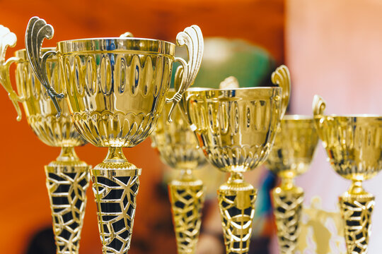 Golden Winner Trophies and Cups Row Displayed for Youth Sports Tournament Award Ceremony - First Place Victory and Success Concept