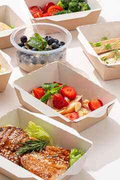 Healthy food delivery ration with grilled chicken teriyaki strawberry dessert blueberry oatmeal and fresh vegetables in meal boxes