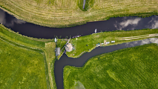 Dutch polder landscape with historic windmill and drainage pump, aerial view of De Wimmenummer Molen in Egmond, Netherlands