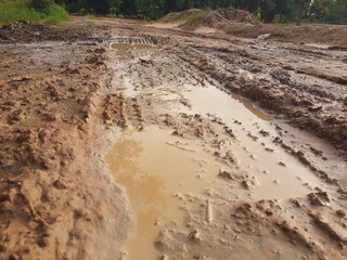 Tire tracks on a muddy dirt road after the rain. © Kitti