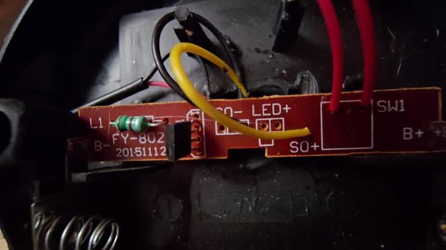  Close-up macro shot of an internal electronic circuit board (PCB) and wiring components from a mini solar-powered garden light.