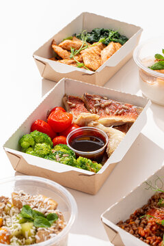 Healthy food delivery ration with grilled chicken teriyaki strawberry dessert blueberry oatmeal and fresh vegetables in meal boxes