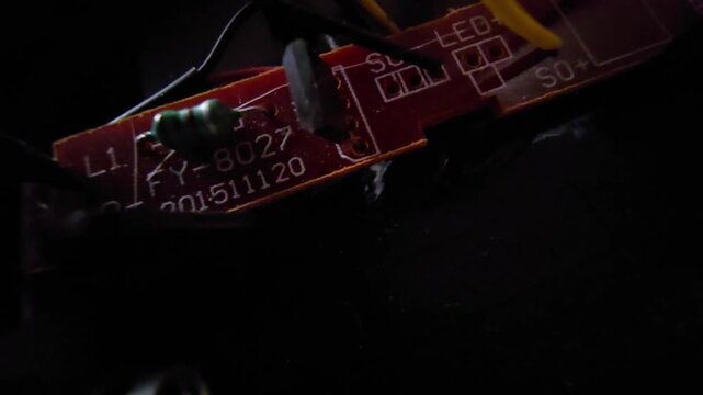  Close-up macro shot of an internal electronic circuit board (PCB) and wiring components from a mini solar-powered garden light.
