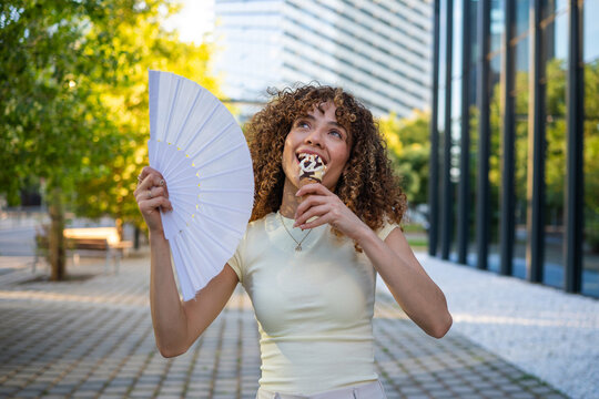 Young woman cooling down eating ice cream during heatwave