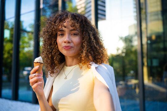 Woman enjoying ice cream cone during city summer walk