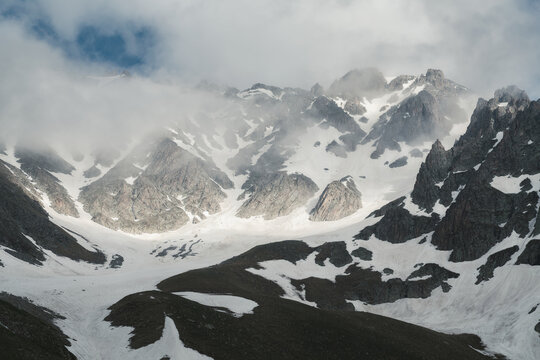 Glacial Cirque Peaks Emerging From Fog With Patches of Blue Sky