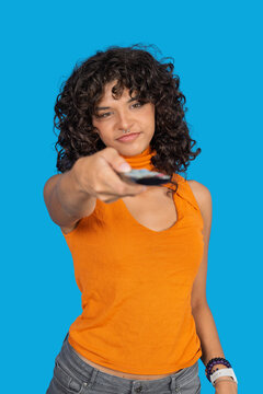 Young woman holding remote control choosing entertainment