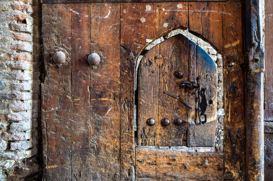 Detail of an Ancient Wooden Door with Small Arched Wicket and Chain, Iran