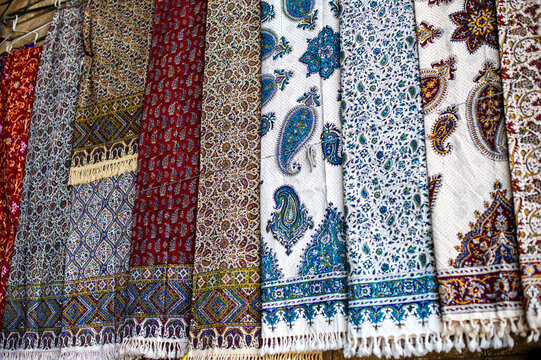 Variety of traditional Persian Ghalamkar printed fabrics with paisley patterns at a bazaar, Iran.