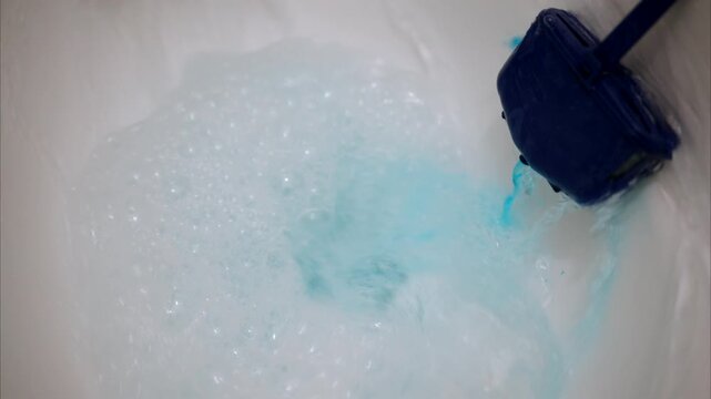toilet flushing with blue soap and water, showing bubbles, liquid, and cleanliness in bathroom.