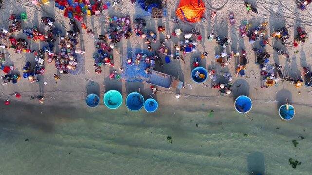 Aerial view of morning seafood market on Doc Let beach, Khanh Hoa province with local vendors and baskets in Vietnam