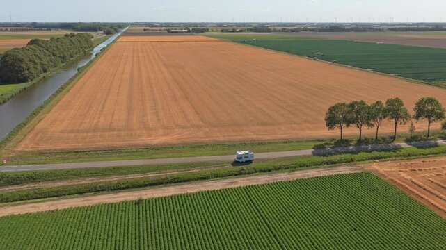 Camper van parked on a country road through dutch polder landscape