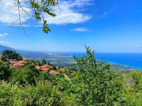 Unsurpassed panorama from the thickets of the mountain forest of the lush blue of the Aegean Sea on the horizon with coastal settlements on the slopes of the mountain hills.