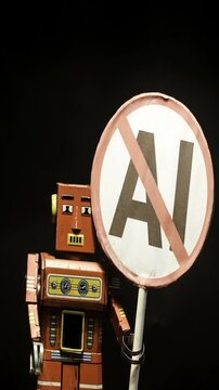 retro robot toy with a stop AI sign 
