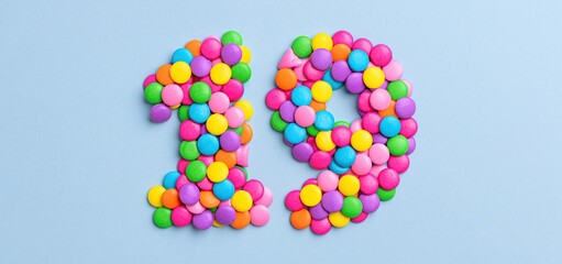 Fototapeta premium Sparkling confetti forming number 19 on a vibrant festive background for holiday celebrations.