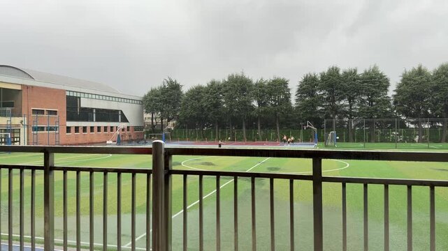 Rainy Multiuse Sports Field with Wet Artificial Turf and Empty Court