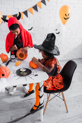 Fototapeta premium Adorable siblings enjoying festive Halloween activities with fun costumes and crafts