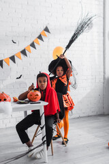 Fototapeta premium Adorable siblings enjoying Halloween festivities in vibrant costumes together