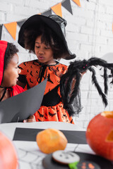 Fototapeta premium Little siblings create spooky memories while celebrating Halloween together