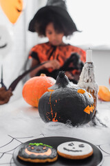 Fototapeta premium Little girl in vibrant Halloween costume enjoys autumn festivities with spooky decorations