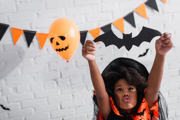 Fototapeta premium Little girl enjoys Halloween festivities with joy and creativity in a vibrant costume