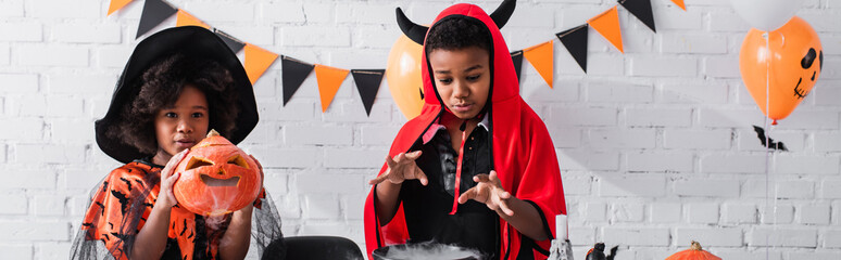 Fototapeta premium Little siblings in vibrant Halloween costumes enjoy a playful spooky celebration