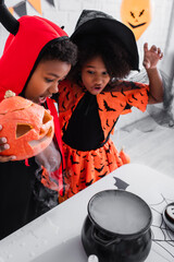 Fototapeta premium Little siblings enjoy Halloween magic together in vibrant costumes