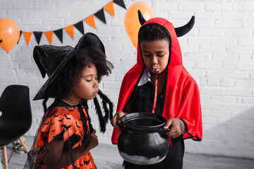 Fototapeta premium Little siblings enjoying Halloween fun in vibrant costumes and sharing spooky moments