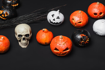Fototapeta premium Spooky Halloween decor featuring colorful pumpkins and a skull on a dark background
