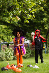 Fototapeta premium Little siblings enjoy Halloween costumes and play in the autumn sun together