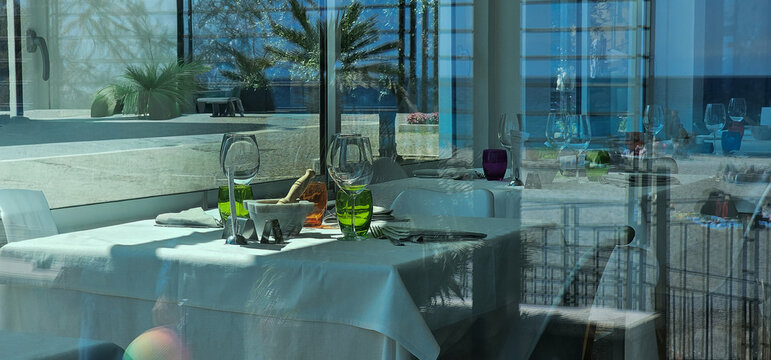 Italian restaurant table behind glass with reflection