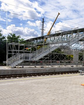 Modern Stadium Grandstand Under Construction with Crane and Overhead Wires