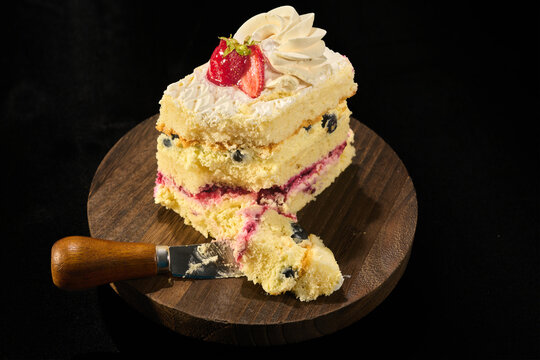 slice of blueberry and huckleberry fruit cake with white fluffy cream