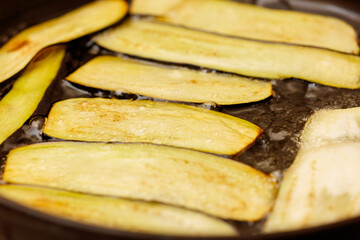 Naklejka na ściany i meble Eggplant slices sizzle in hot oil