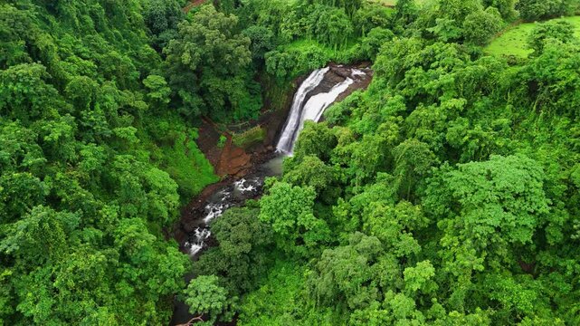 Aerial View Revealing Ashoka Waterfall Near Nashik, Maharashtra, India, Gradually Uncovering Cascading Monsoon Water Surrounded by Lush Green Forest, Rocky Terrain and Scenic Western Ghats Landscape