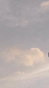 Animation of stone sculpture over sky with clouds