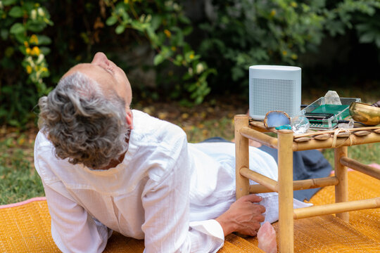 Woman gently transitioning from a relaxation practice beside a Schumann wave generator and crystal healing tools, supporting mindfulness, emotional restoration, and spiritual wellness.
