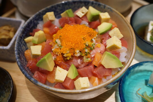 Close-up of Japanese diced sashimi rice bowl, bara chirashi don topped with tobiko, tuna, salmon, avocado and tamagoyaki.