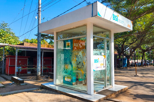 Makassar, Indonesia, August 06, 2026,  A glass-walled ATM booth featuring a modern design and white pillars adorned with the BSI logo.